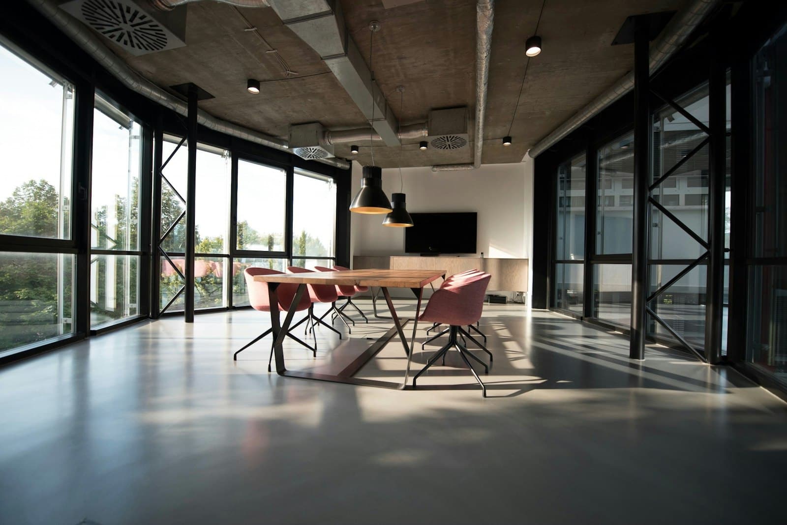 Tidy open-plan office with a meeting table and large windows